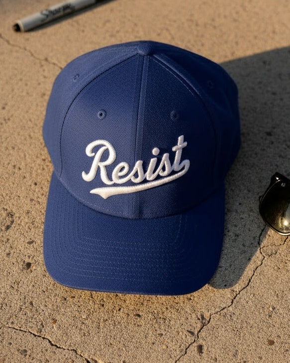 Blue cap with 'Resist' text on a cracked pavement surface
